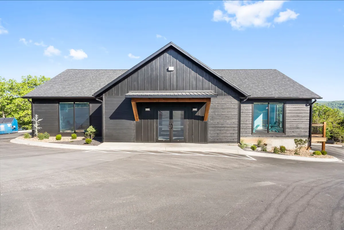 The modern architectural facade of the main building, accented by warm wooden features and expansive windows. The entryway hints at spacious interiors designed for group gatherings, meetings, or celebrations—an ideal environment for hosting corporate groups and fostering collaboration.